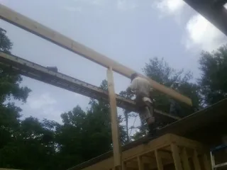 Carpenter setting a ridge beam over a new addition frame — Ice Dam Removal by Roofing Brothers in Eure
