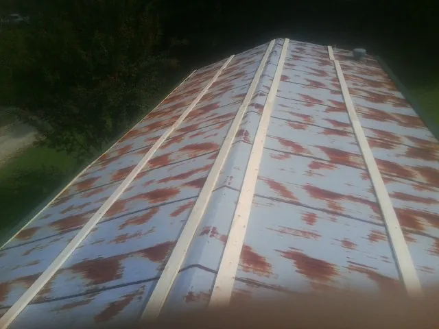Rusted metal roof panels with new wood purlins before replacement — Storm Damage Roof Repair in Eure by Roofing Brothers