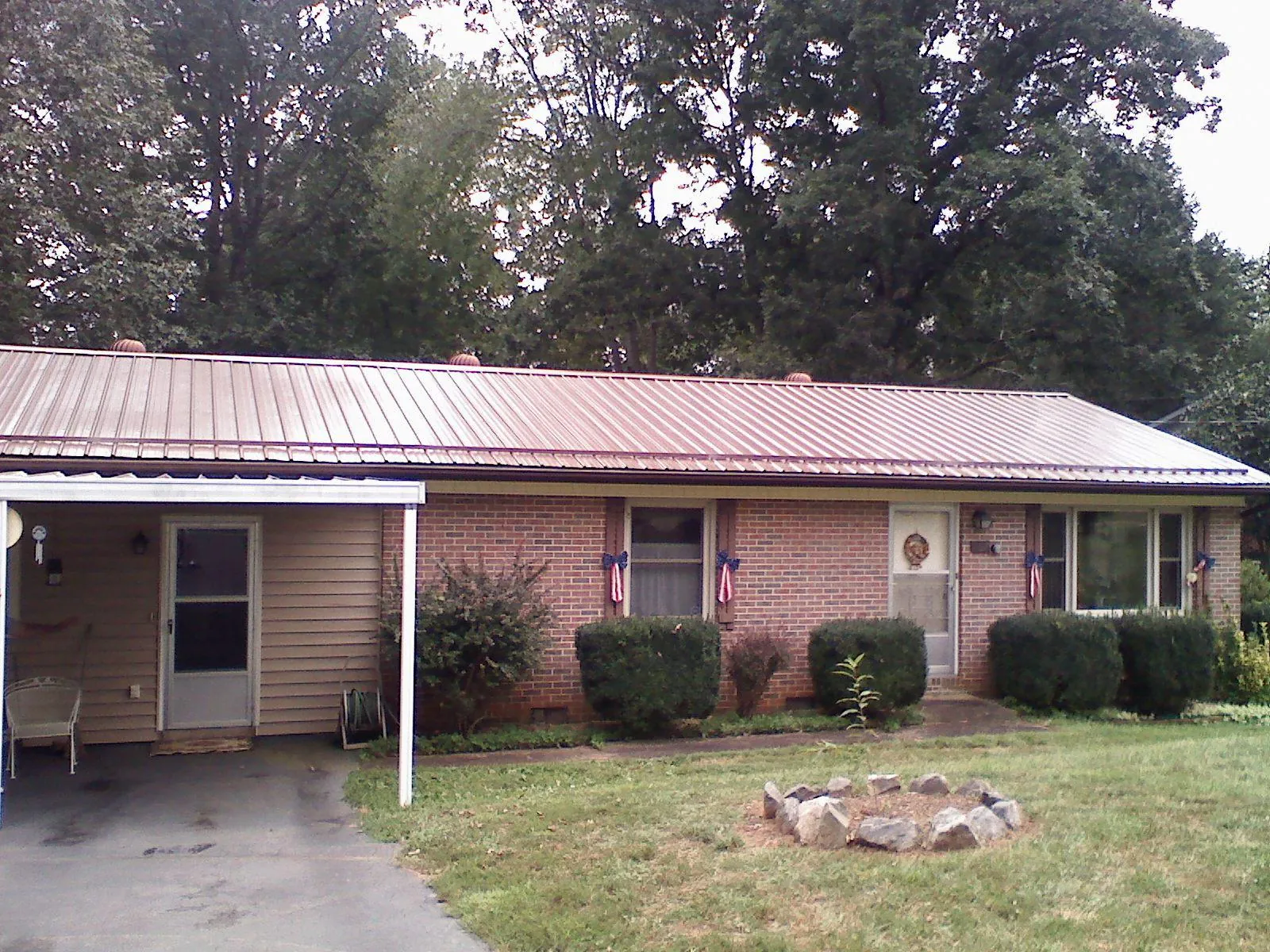 Bronze metal roof and carport on a brick ranch home — Roof Repair work by our crew in Eure